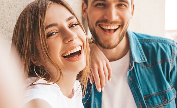 a couple smiling after getting dental checkups and cleanings