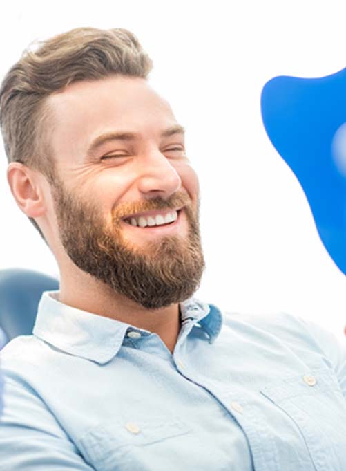 Man admiring his new dental bridge in Lakewood Dallas