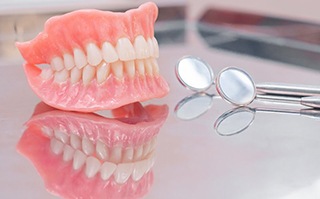 a pair of dentures next to dental tools