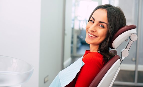 Woman smiling while visiting a Lakewood, Dallas emergency dentist