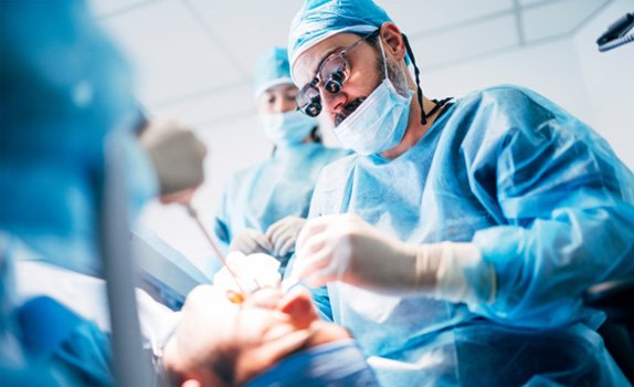 Dental team carefully performing procedure as part of full mouth reconstruction