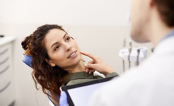 Woman asking questions about dental implants in Lakewood, Dallas