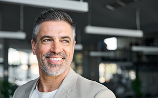 a man smiling after getting dental implants in Lakewood