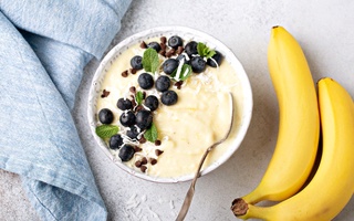 Bowl of porridge next to bananas