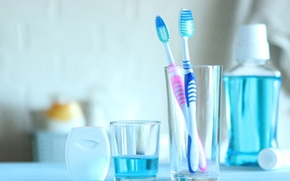 Toothbrushes in cup next to mouthwash
