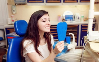 teenage girl admiring her smile after Invisalign treatment