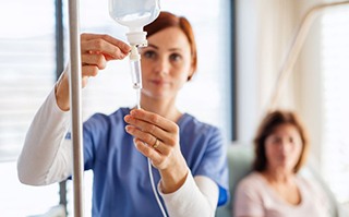 Dental team member preparing an IV for patient