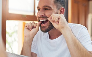 A man flossing his teeth