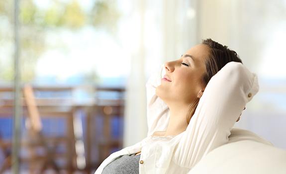 Woman in a white shirt relaxing on the couch