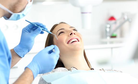 Relaxed woman smiles during appointment with sedation dentist