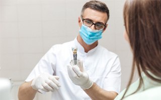 a dentist in Lakewood explaining how dental implants work