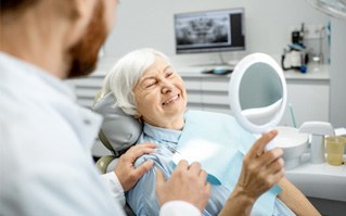 a patient smiling after receiving her dental implant restorationsn
