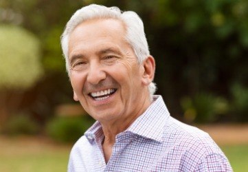 Man smiling after replacing missing teeth