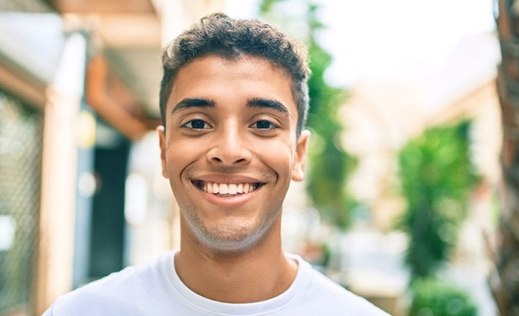 a teenager standing outside and smiling