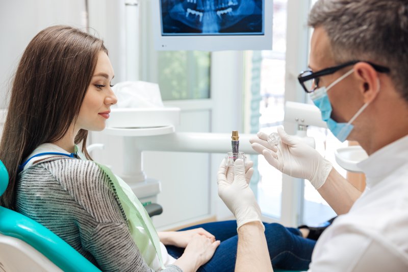 A dentist explaining how dental implants work