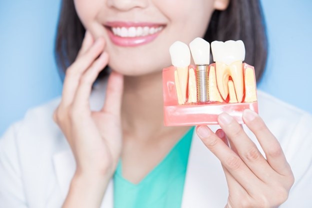 dentist holding model of a dental implant