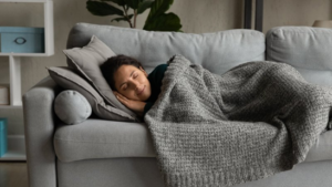 Woman sleeping on the couch with her weighted blanket
